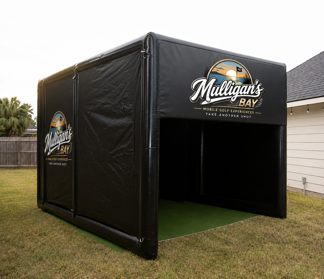 The Mulligan's Bay branded inflatable mobile golf simulator bay set up on a lawn